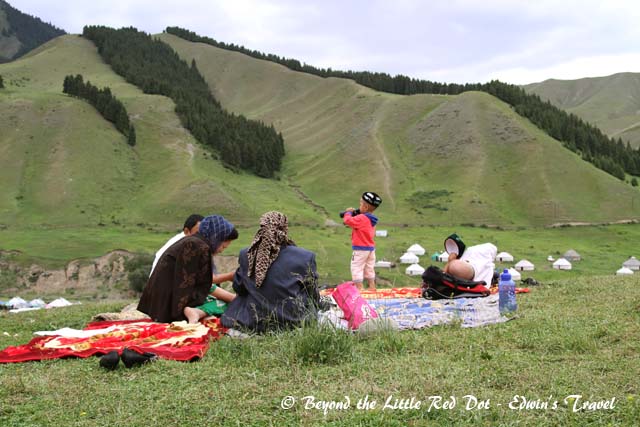 A Kazakh family enjoying a picnic on top of a hill.