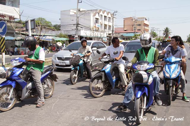 View from the back of the tuk-tuk. The riders in green vests are motorcycle taxis.