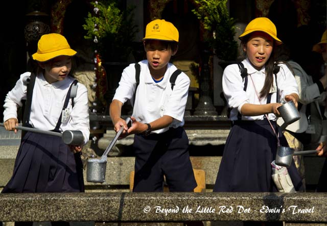 Students collecting the water from the waterfall.