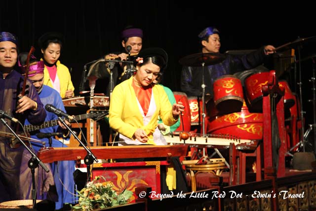The performance is accompanied by a live orchestra of traditional Vietnamese instruments.
