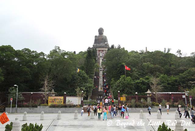 You have to climb up the steps to the base of the Buddha.