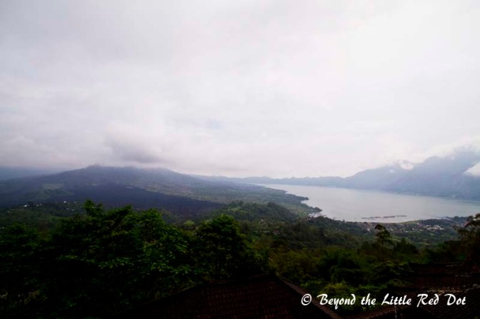 Mt Batur on the left hidden in clouds, Lake Batur on the right with the cauldera rim. The black lava from the last eruption can be seen.