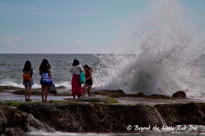 More Chinese tourists trying to get a selfie with the waves breaking behind them.