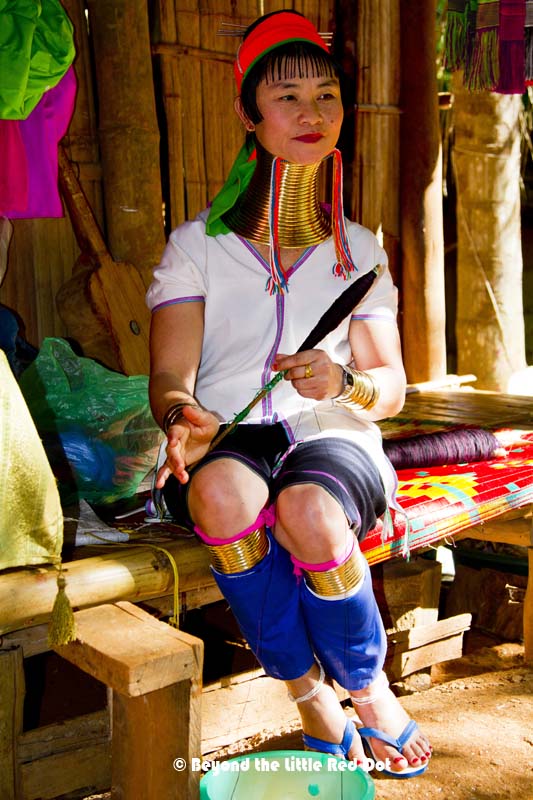 One of the older women in the village. The older women have longer necks as they add more rings as they age.