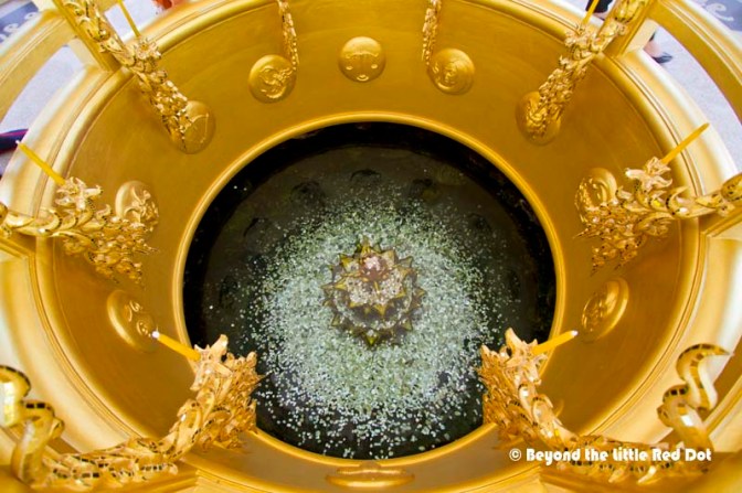 A wishing well beside the golden building.