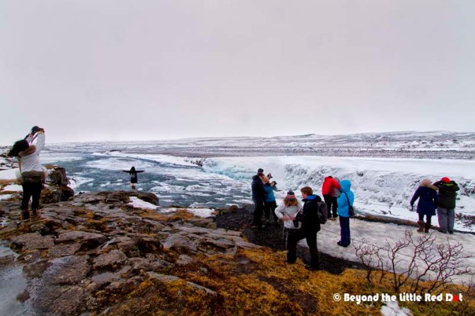 As usual, tourists like the girl standing on the edge of the cliff tempting fate. One slip on the icy rocks and no one will save her.