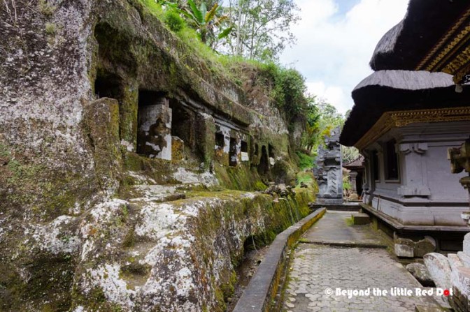 The ancient temple carved into the cliff and the modern buildings beside it.